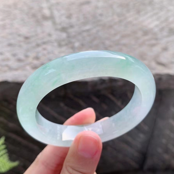 冰淡绿翡翠贵妃手镯 种水冰润起胶，飘绿清新甜美，十分赏心悦目，无裂纹。 圈口：53.7+49.3/12.3/9.3mm 价格：小六一开