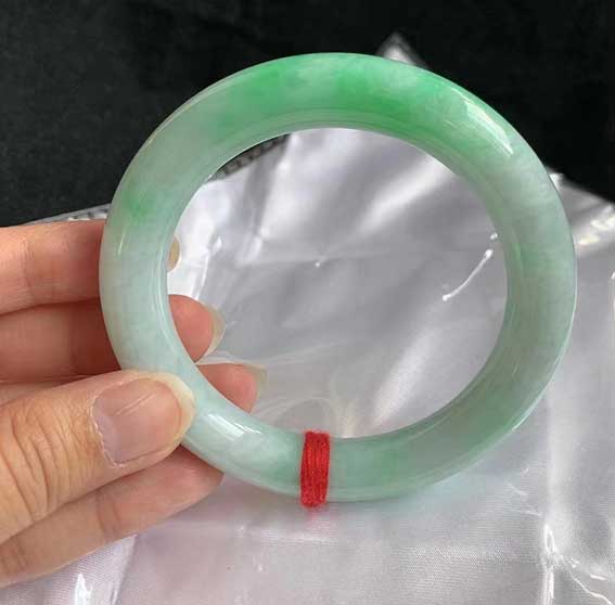 翡翠飘绿圆条手镯  尺寸：57.4/11.3/10.8 自然光拍摄的，喜欢带颜色的可以考虑这个，性价比不错的。 特价两万多