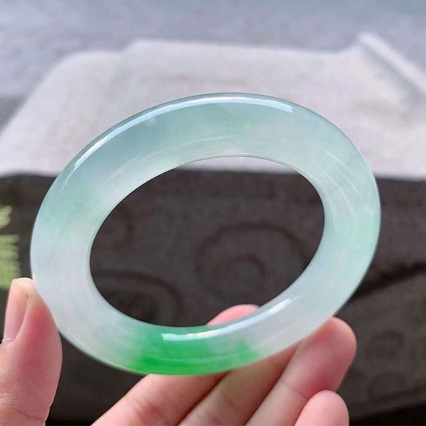 翡翠【手镯】冰润阳绿圆条 【圈口】57/12.7/12.4mm 【价格】小六价 【描述】水润欲滴起胶感，料子很细腻温润，一段阳绿色娇艳夺目，亭亭玉立