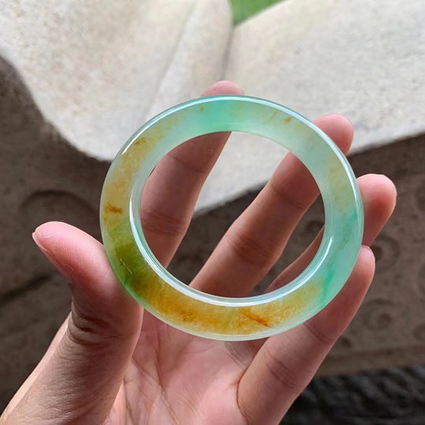 收藏级别圆条黄加绿特色种水镯 尺寸:52/10.5/10.5mm 收藏级别，当翠色欲滴的绿色遇上明亮鲜活的黄色，富有层次感的色彩，黄与绿和谐融合，颜色极致诱惑，让人观之喜悦。