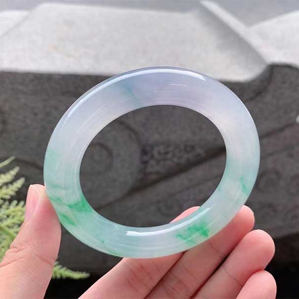 蓝紫飘绿花圆条手镯 尺寸：56.9/12.6/12.5mm 玉质冰润润的，水头好，冰蓝紫底，飘绿花，色泽明艳灼人，散发着迷人魅力，上手低调奢华， ：六位数    喜询~